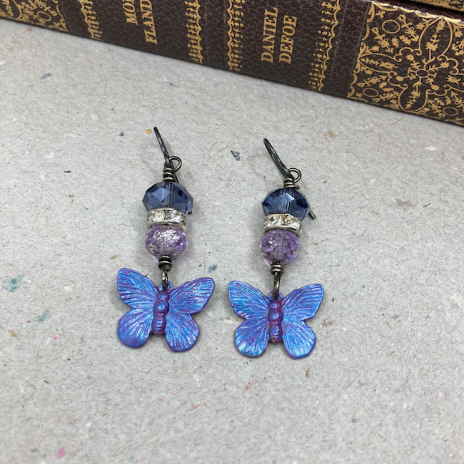 Earrings with blue and purple beads, clear crystal accents and blue and purple butterfly charms. 