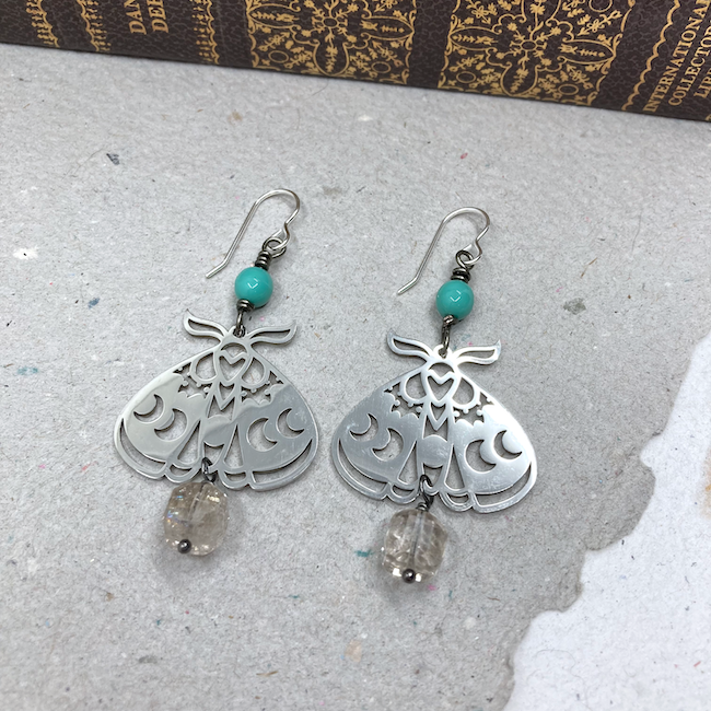 Earrings with silver moth charms, gemstone square dangles and turquoise color round beads. 