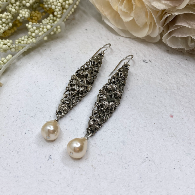 Elongated antiqued silver filigree connectors and off white glass pearls. 