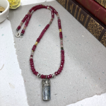 Necklace with small silver soldered blue kyanite pendant, ruby crystals, multicolored tourmaline, sterling silver and gold spacers.
